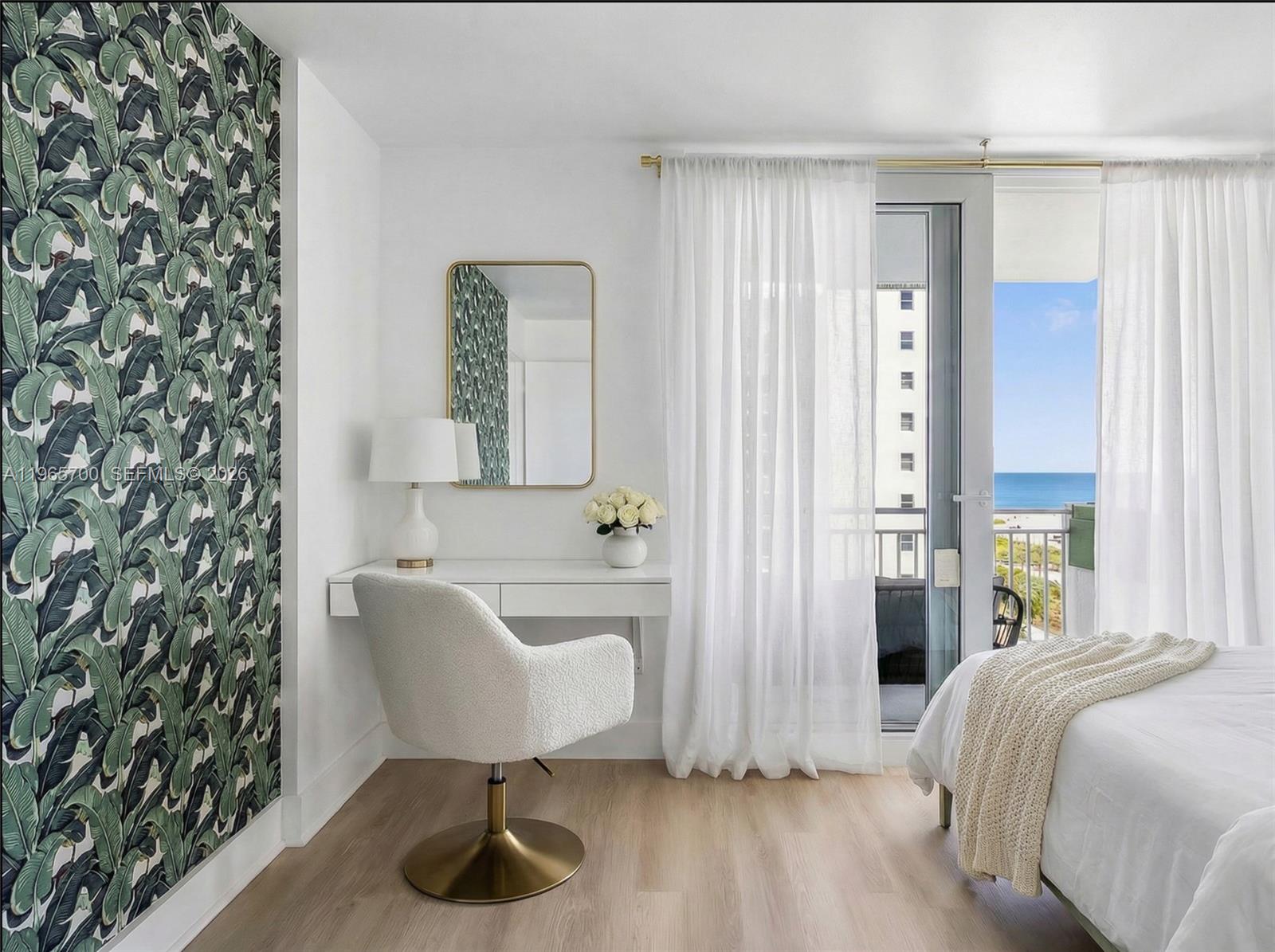 A bedroom features a vanity with a gold-framed mirror, tropical wallpaper, and a balcony view — 345 Ocean Dr # 718, Miami Beach FL 33139, MIAMI BEACH, FL