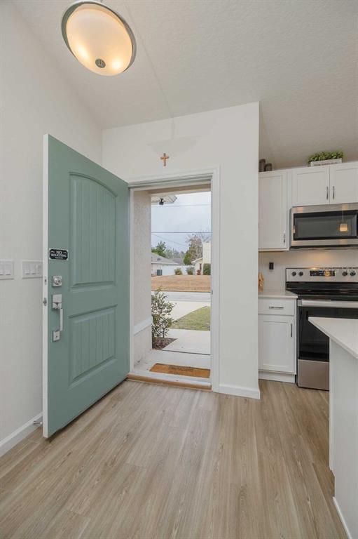 An open door reveals a view of a street from a kitchen with white cabinets — 42 WOODBORN LANE, PALM COAST, FL