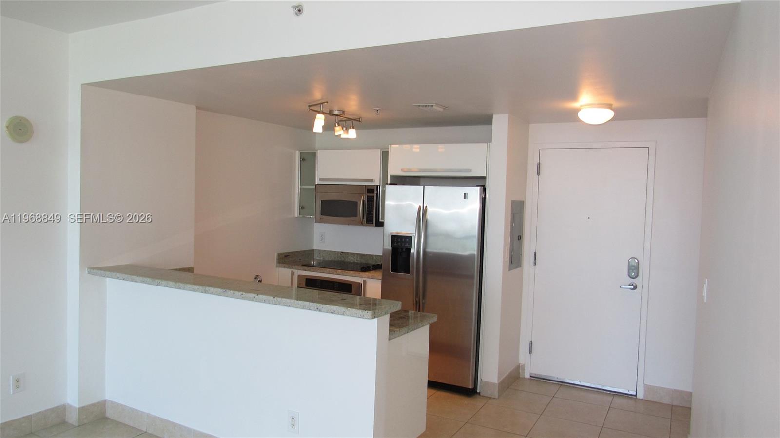 A kitchen with stainless steel appliances, white cabinets, and a granite-topped breakfast bar — 601 NE 36th St # 2308, Miami FL 33137, MIAMI, FL
