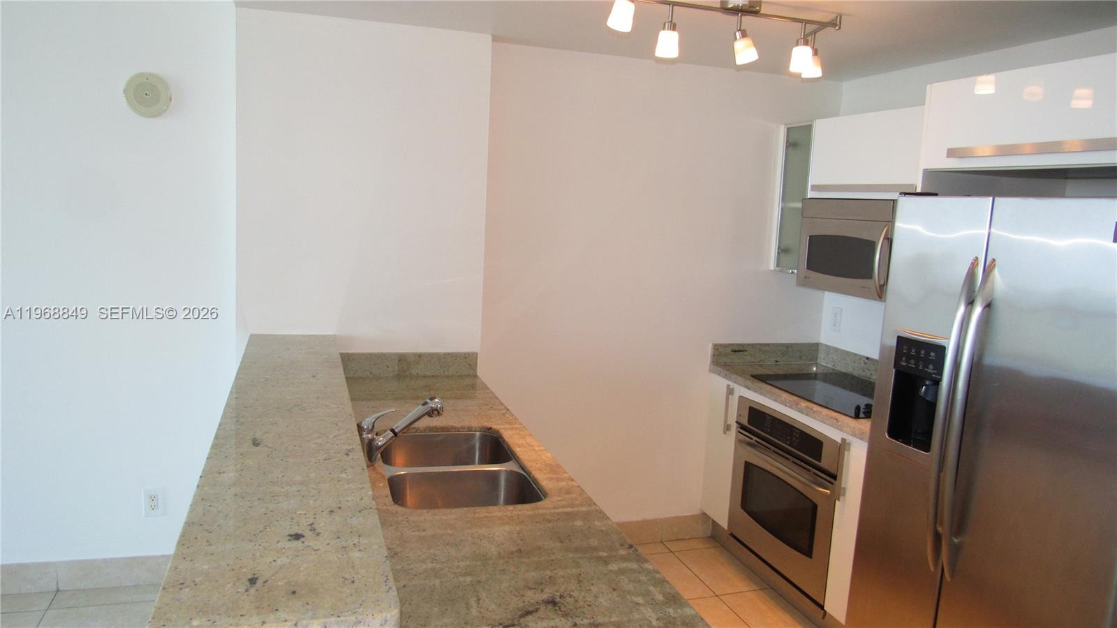 A kitchen features granite countertops, stainless steel appliances, and a double basin sink — 601 NE 36th St # 2308, Miami FL 33137, MIAMI, FL