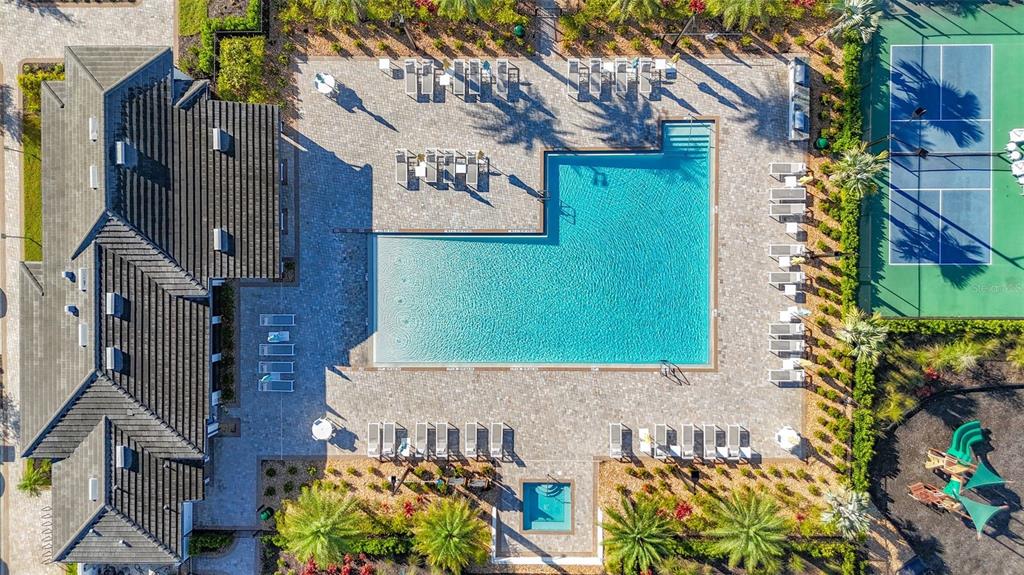 An aerial view shows a swimming pool, tennis court, playground, and building with a roof — 5414 LATCHES LANE UNIT 3B-Haven, LAKEWOOD RANCH, FL