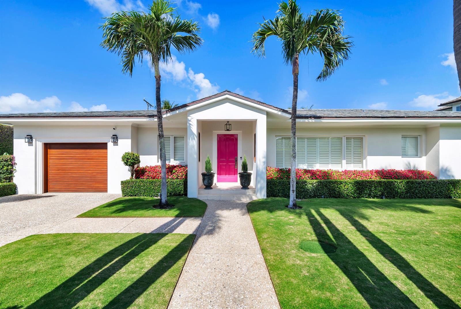 A single-story house features a bright pink front door, two palm trees, and a garage — 225 Jamaica Lane, Palm Beach FL 33480, PALM BEACH, FL