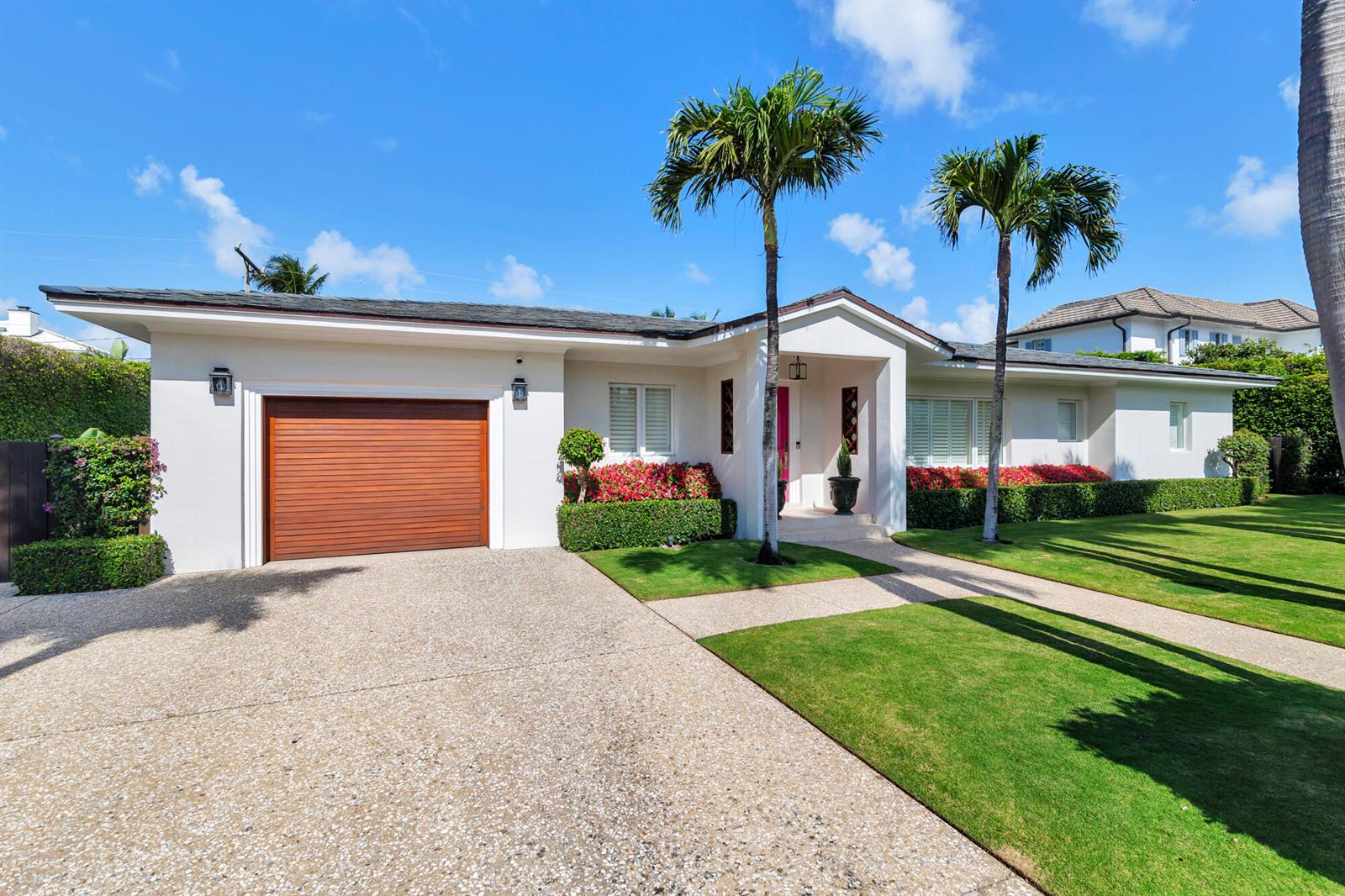 A single-story white house with a wooden garage door and two palm trees in front — 225 Jamaica Lane, Palm Beach FL 33480, PALM BEACH, FL