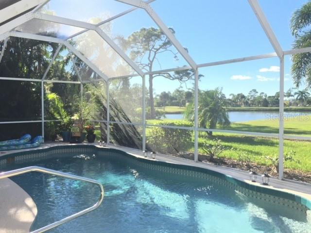 A screened-in swimming pool overlooks a grassy lawn and a pond on a sunny day — 3001 KING TARPON DRIVE, PUNTA GORDA, FL