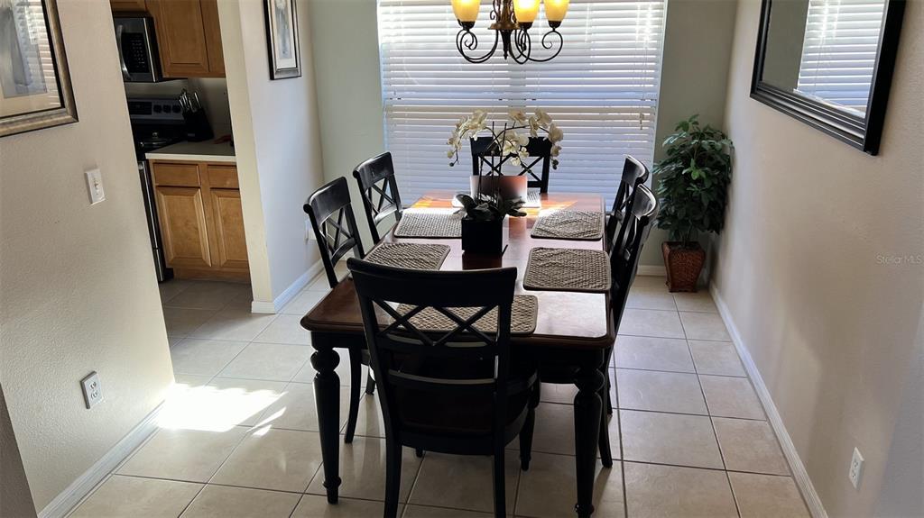 A dining room features a wooden table with six chairs, tile flooring, and a chandelier — 345 SOLANA CIRCLE, DAVENPORT, FL
