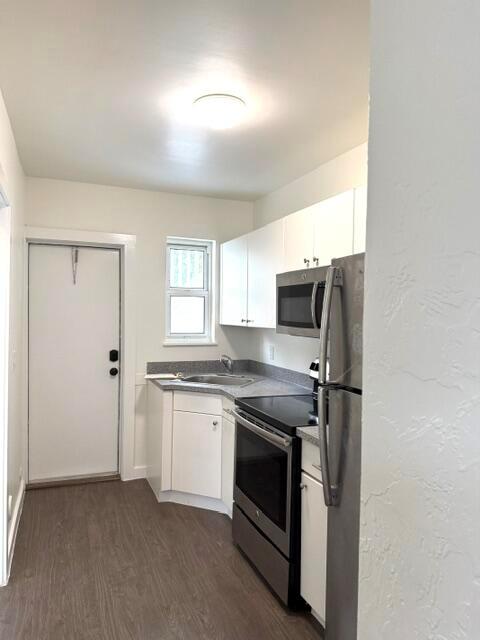 A bedroom features a bed with green accents, two nightstands, and a ceiling fan — 715 2nd Avenue S # 3, FL 33460, FL