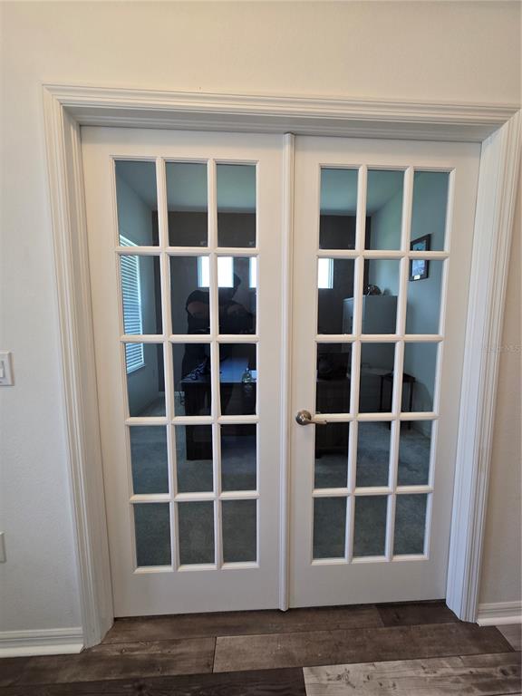 A set of white French doors with glass panes leads into a home office — 863 W BAYSHORE DRIVE, TARPON SPRINGS, FL