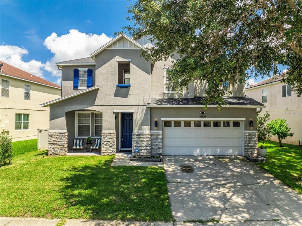 A two-story suburban house with a gray stucco exterior, stone accents, and a two-car garage — 10109 STRATFORD POINTE AVENUE, ORLANDO, FL