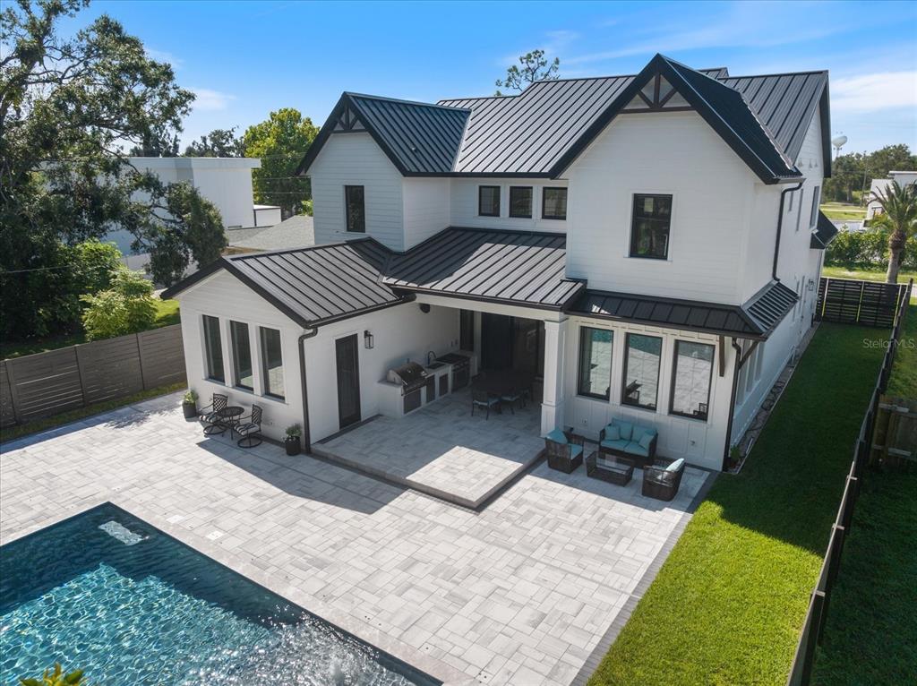 An aerial view of a white two-story house with a metal roof, pool, and patio — 2045 GOLDENROD STREET, SARASOTA, FL