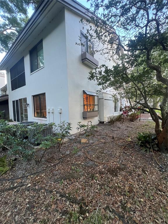 The exterior of a two-story white stucco building features a bay window and landscaping — 1721 LAKE CYPRESS DRIVE UNIT 2101, SAFETY HARBOR, FL