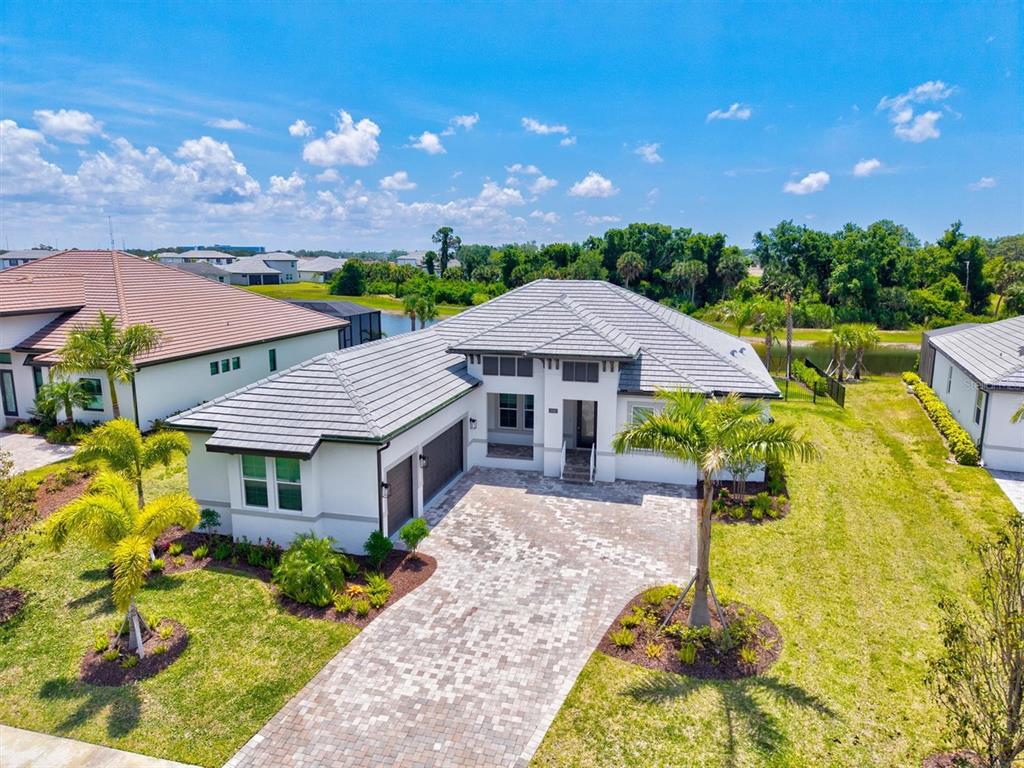 An aerial view of a single-story house with a tiled roof and paver driveway — 1154 KINGS WAY DRIVE, NOKOMIS, FL