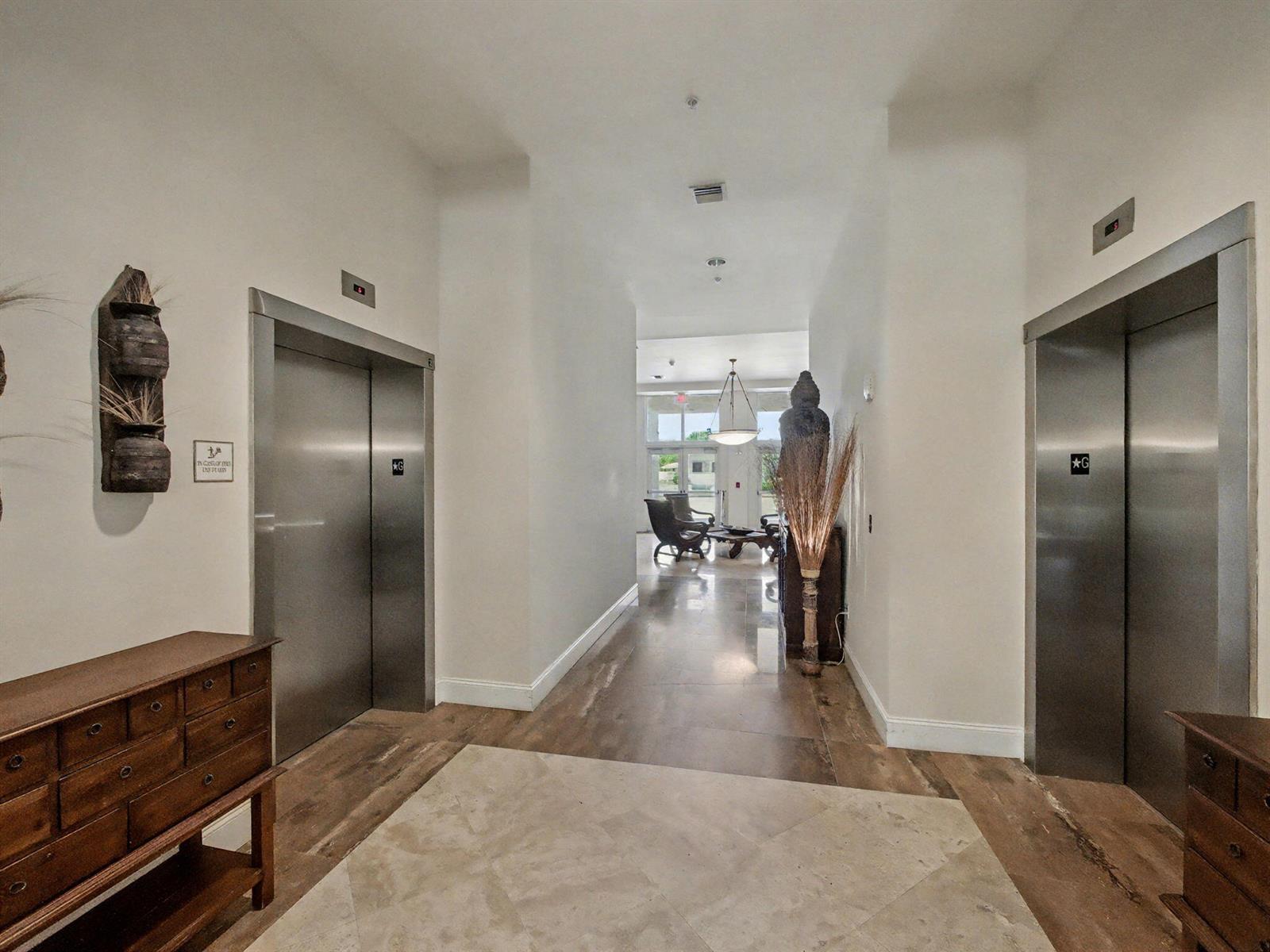 An elevator lobby with stainless steel doors, wood-look flooring, and a view into a lounge — 2600 SW 27th Avenue # 603, Miami FL 33133, MIAMI, FL