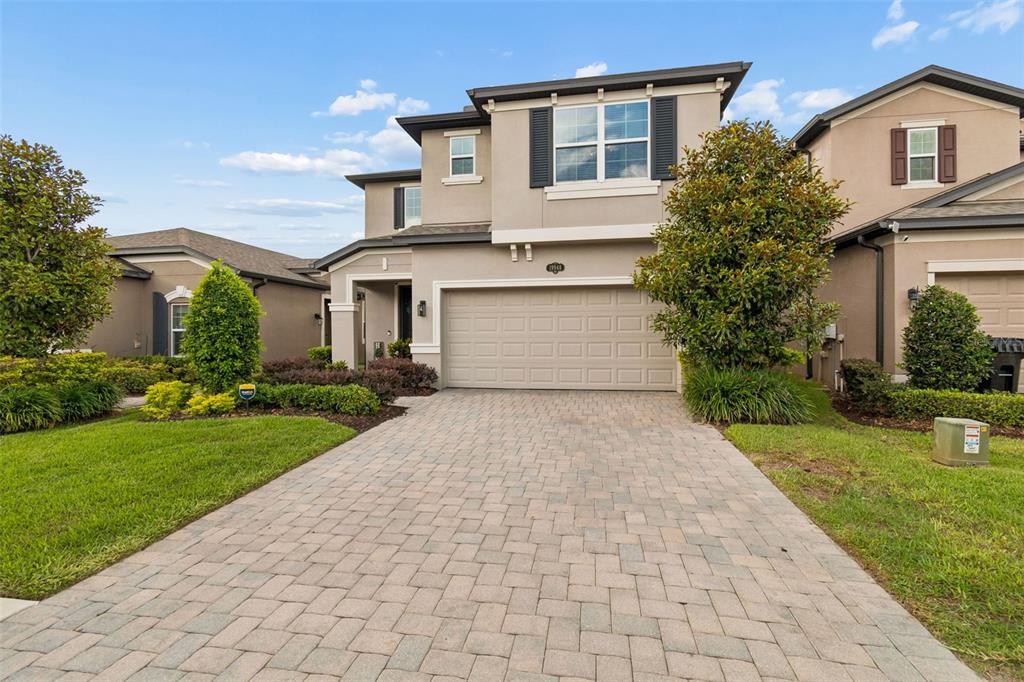 A two-story suburban house with a beige stucco exterior and a paved driveway — 19948 STONE PINE CIRCLE, LUTZ, FL