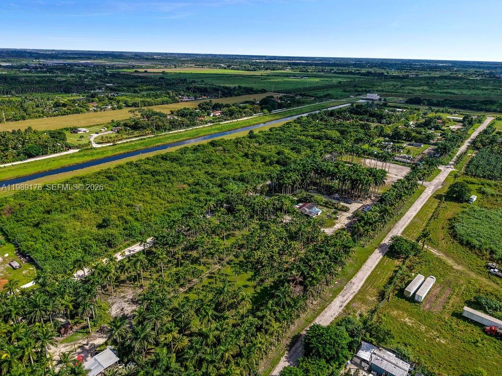 An aerial view shows a rural property with dense palm trees, a canal, and structures — 10650 SW 206th Ave, Miami FL 33187, MIAMI, FL