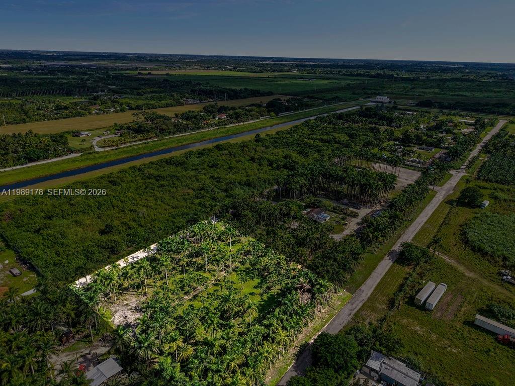 An aerial view shows a palm tree grove situated next to a rural road — 10650 SW 206th Ave, Miami FL 33187, MIAMI, FL