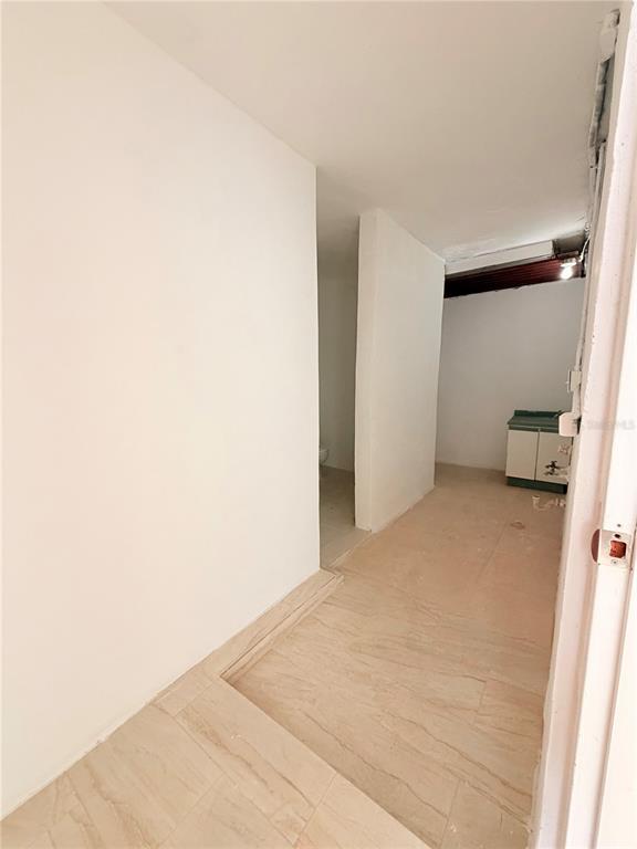 An interior view shows a tiled room with a small sink cabinet and a doorway — Calle 601 BLOQUE 224 COMERCIAL 2, CAROLINA, PR