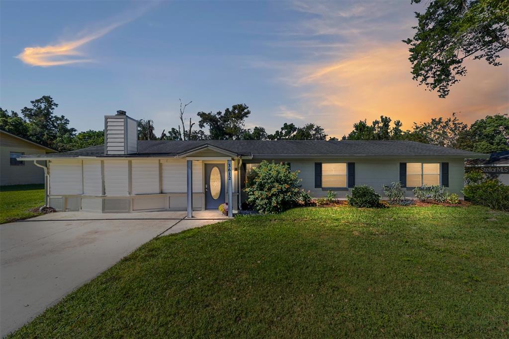 A single-story house with a light-colored exterior, a chimney, and a concrete driveway — 3612 SE 34TH COURT, OCALA, FL