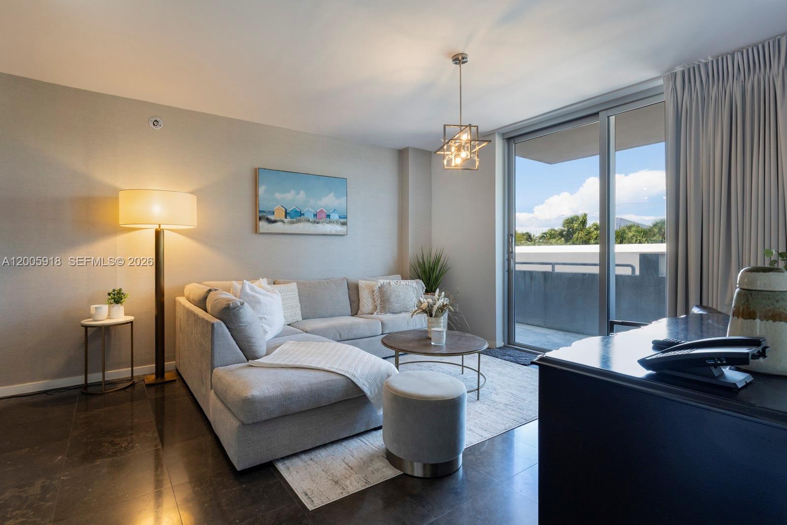 A living room features a grey sectional sofa, a round coffee table, and a balcony — 220 21st St # 303, Miami Beach FL 33139, MIAMI BEACH, FL