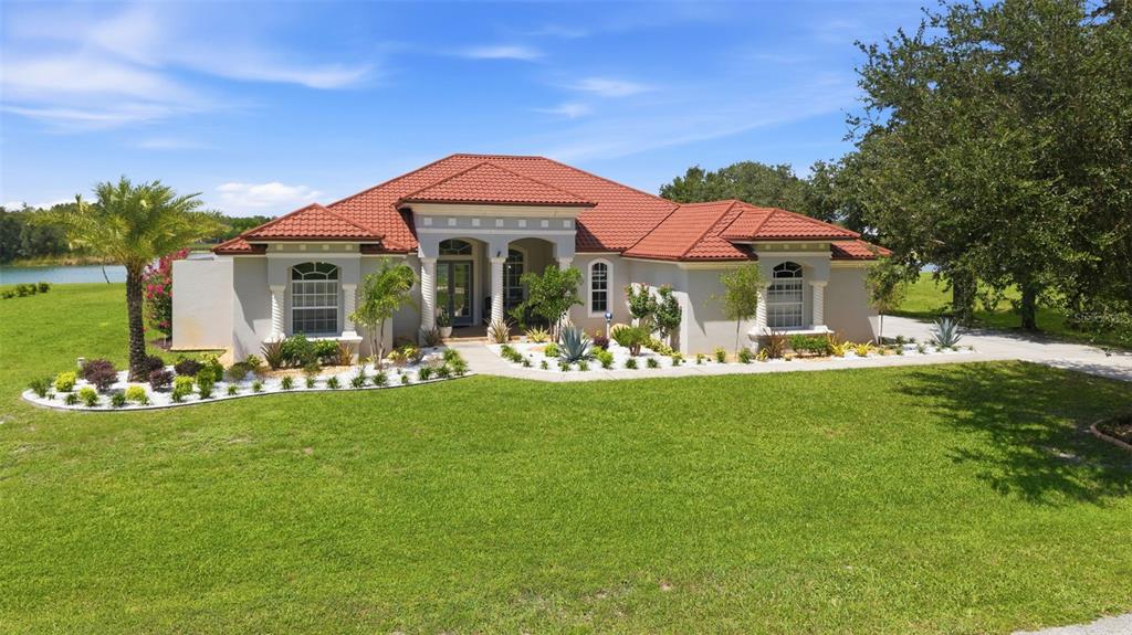 A single-story house with a red tile roof and a landscaped front yard — 24355 HIDEOUT TRAIL, LAND O LAKES, FL