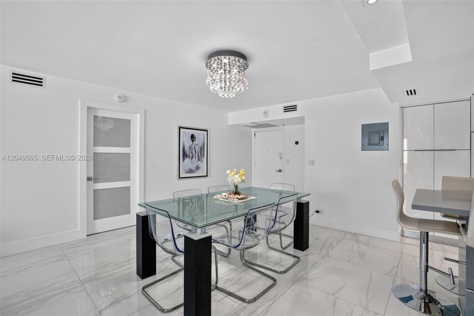 A modern galley kitchen features white cabinetry, stainless steel appliances, and a gray countertop — 6039 Collins Ave # 1624, Miami Beach FL 33140, MIAMI BEACH, FL