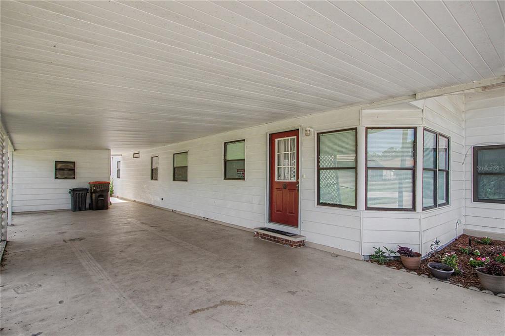 A white single-story house features a concrete driveway and an attached carport — 8145 SW 64TH AVENUE, OCALA, FL