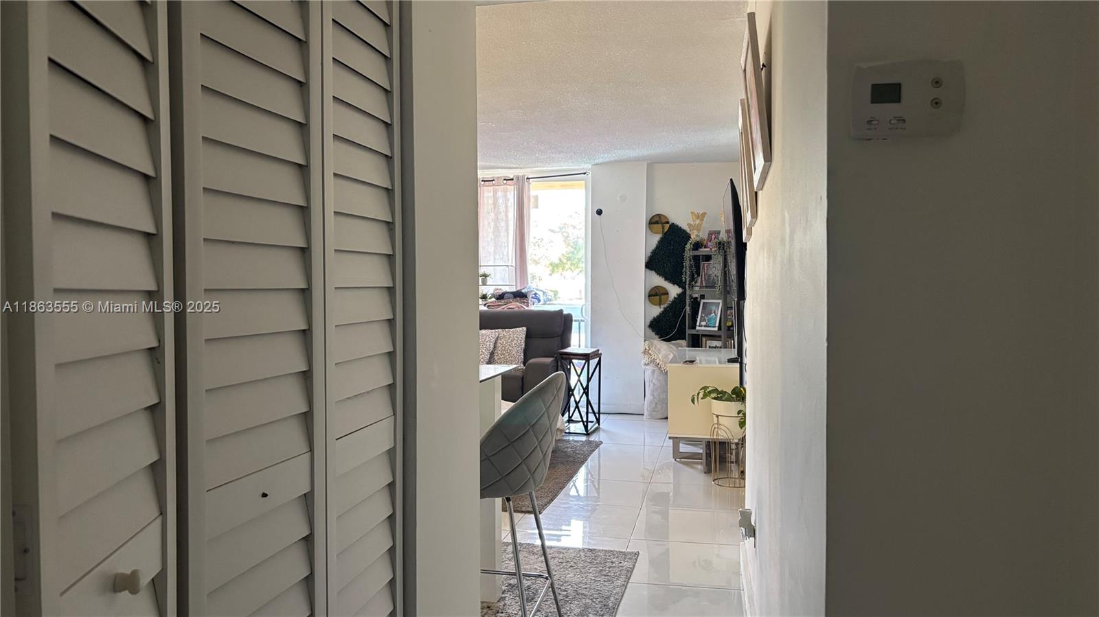 A view through a doorway shows a living area with tile floors and a closet — 2075 NE 164th St # 105, North Miami Beach FL 33162, NORTH MIAMI BEACH, FL