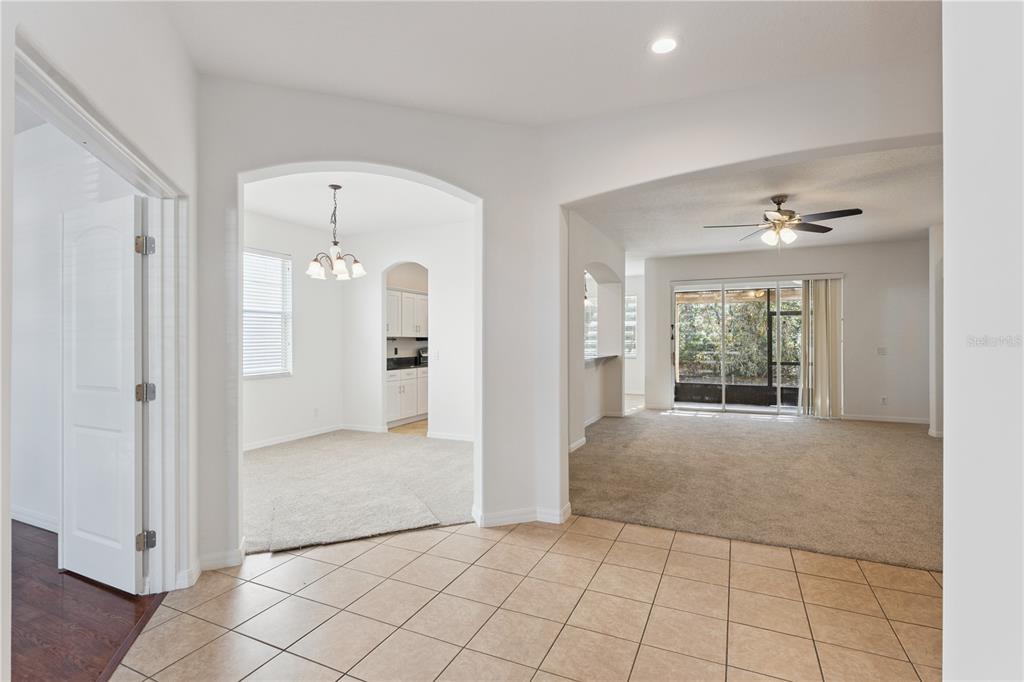 A tiled entryway opens into a carpeted dining area and a living room with sliding doors — 5295 ADAIR OAK DRIVE, ORLANDO, FL