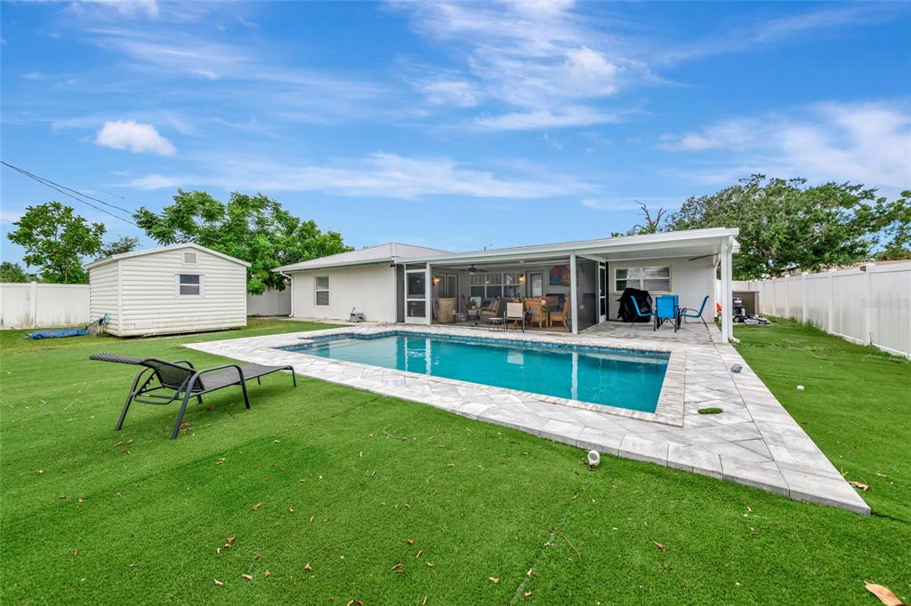 A backyard features a rectangular swimming pool, a covered patio, and a detached storage shed — 509 RIDGEWOOD STREET NW, PORT CHARLOTTE, FL