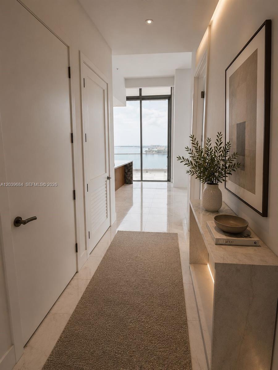 A bright hallway with marble floors leads to a glass door overlooking the water — 175 SE 25th rd # 1503, Miami FL 33129, MIAMI, FL