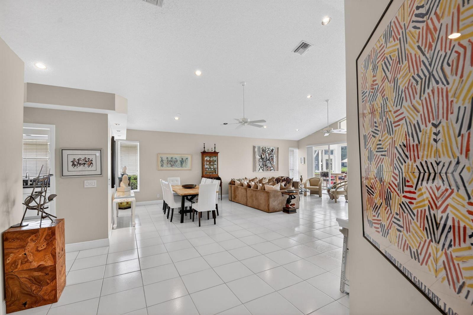 A spacious open-concept living and dining area with white tile floors and neutral walls — 6400 Three Lakes Lane, Boynton Beach FL 33437, BOYNTON BEACH, FL