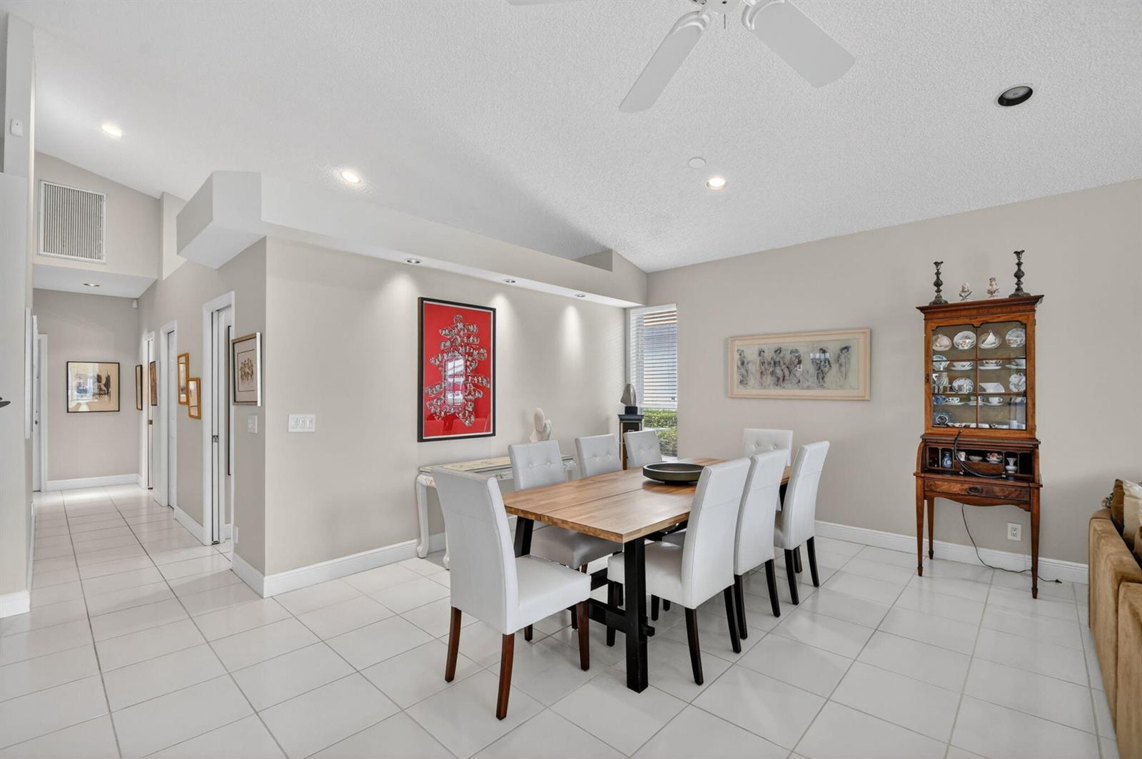 A dining room features a wooden table, white chairs, tile flooring, and a wooden hutch — 6400 Three Lakes Lane, Boynton Beach FL 33437, BOYNTON BEACH, FL