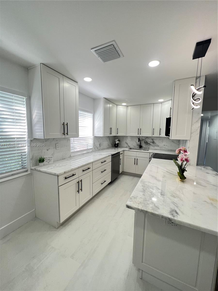 A modern kitchen features white shaker cabinets, marble countertops, and a central island — 708 Normandy O # 708, Delray Beach FL 33484, DELRAY BEACH, FL