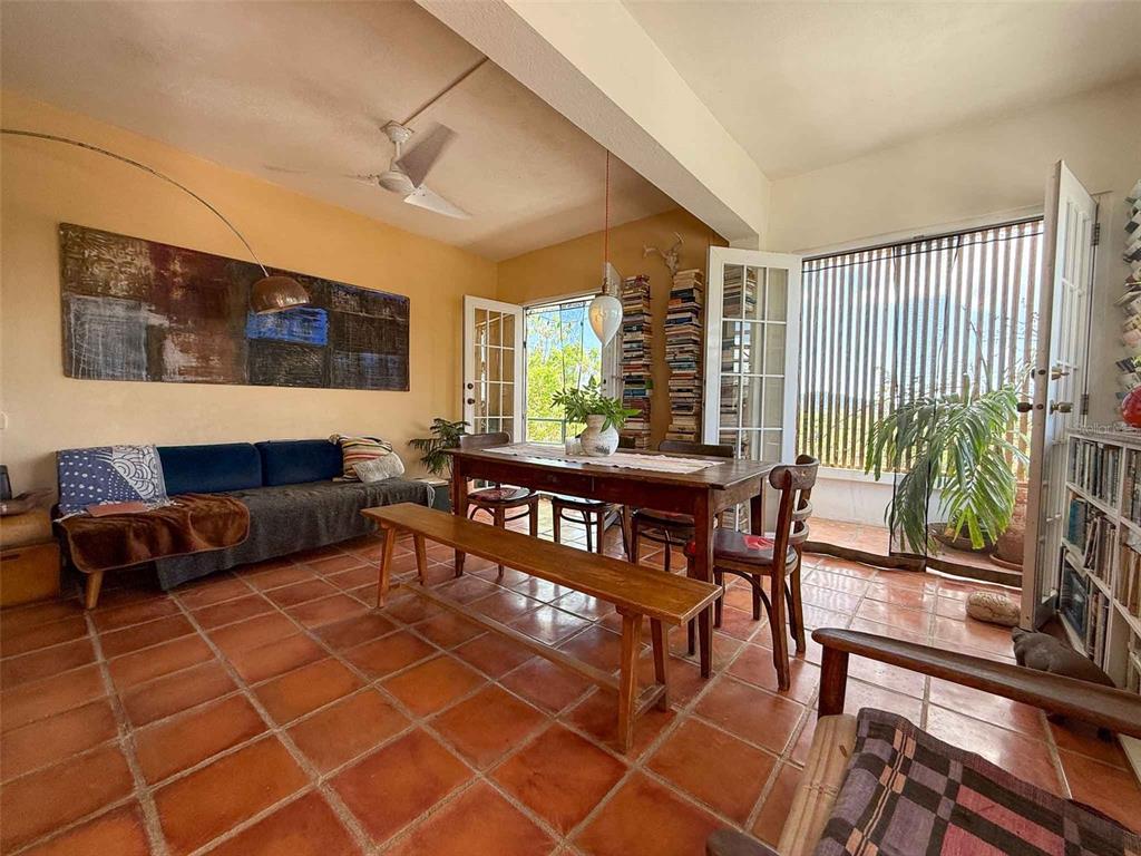 A living and dining area features terracotta tile floors, a wooden table, and a sofa — 213 CALLE IGLESIAS, VIEQUES, PR