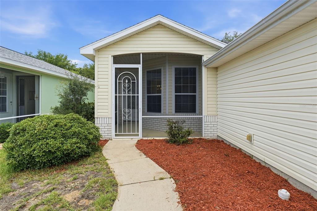 A single-story house with yellow siding, a two-car garage, and a concrete driveway — 4962 RAINBOW TROUT ROAD, TAVARES, FL