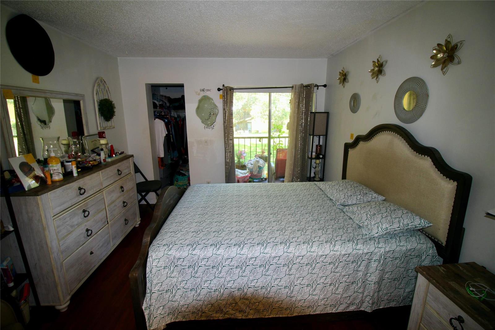 A bedroom features a bed with a patterned comforter, a dresser, and a sliding glass door — 316 Meadows Circle # 316, Boynton Beach FL 33436, BOYNTON BEACH, FL