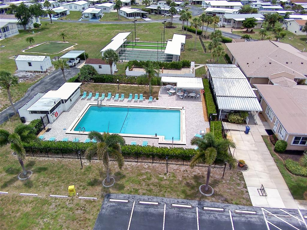 An aerial view shows a community swimming pool, tennis courts, and surrounding residential mobile homes — 498 LONGWOOD DRIVE, VENICE, FL