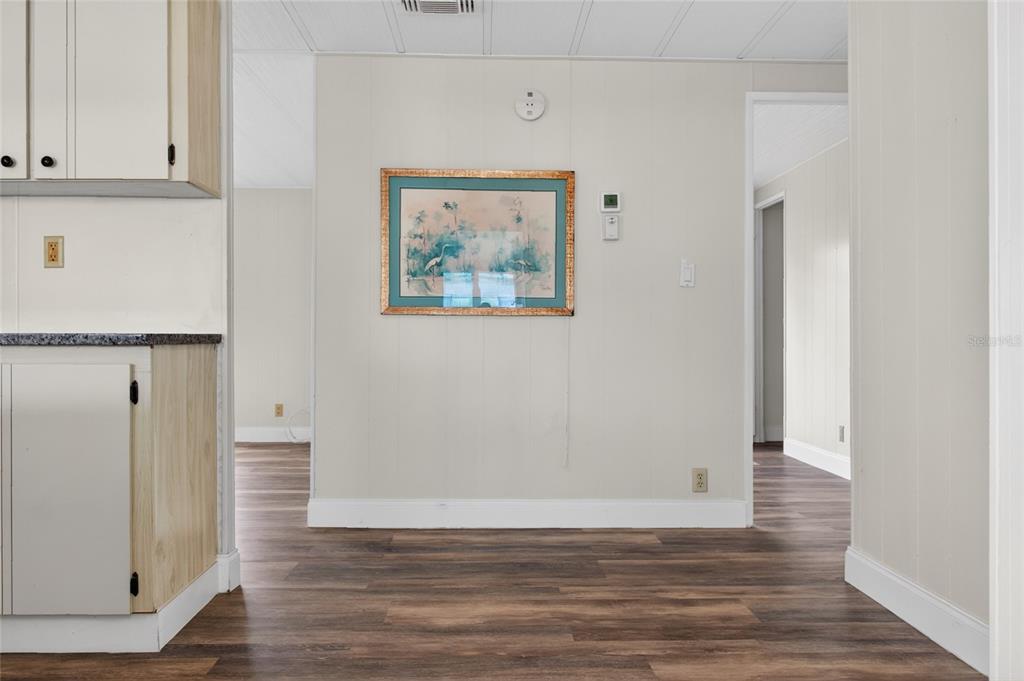 A view of a room with wood-look flooring, light-colored walls, and a framed wall picture — 498 LONGWOOD DRIVE, VENICE, FL