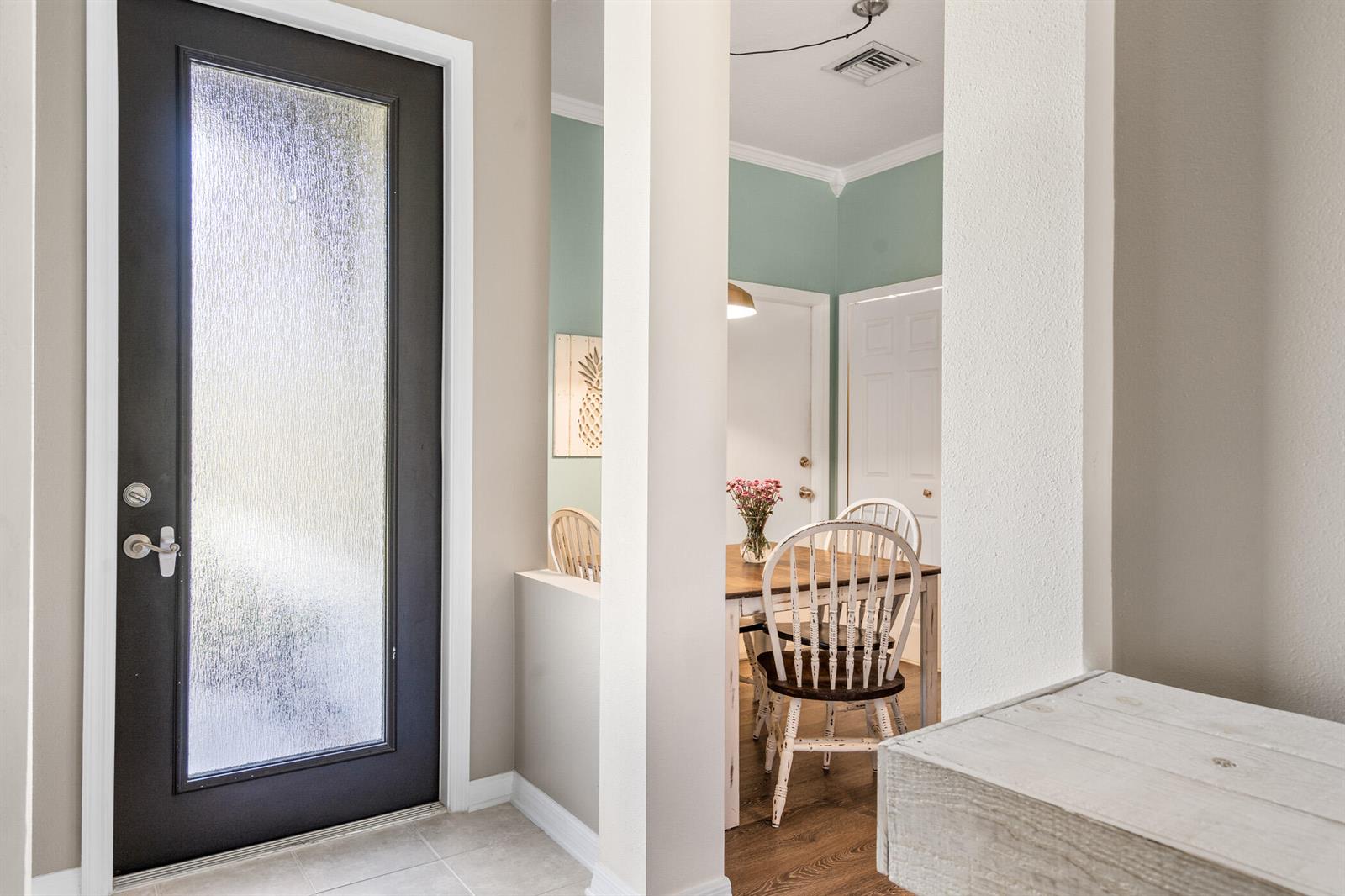 A view from a tiled entryway looking into a dining room with light green walls — SEBASTIAN, FL