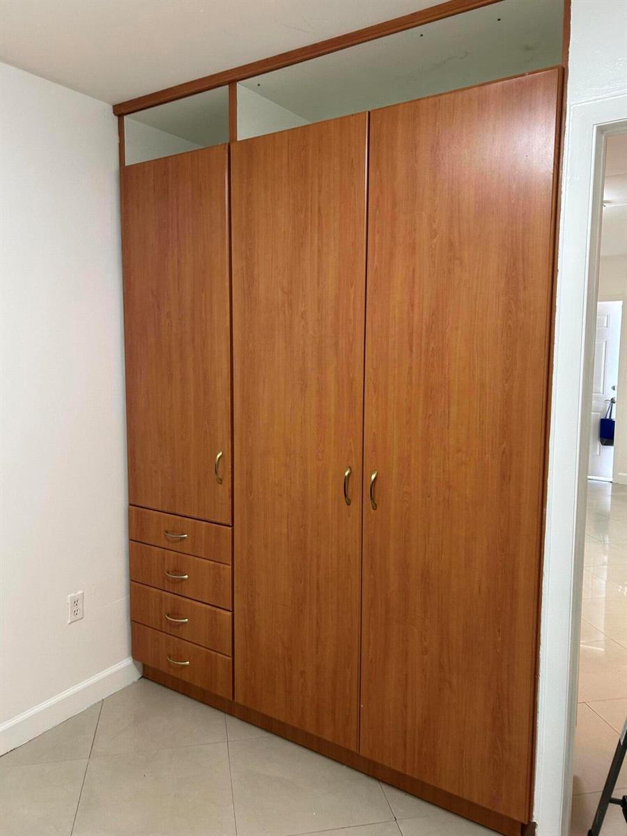 A tall, wooden wardrobe with a single door, four drawers, and upper storage compartments — 210 SE 9th Street # 1, Hallandale Beach FL 33009, HALLANDALE BEACH, FL