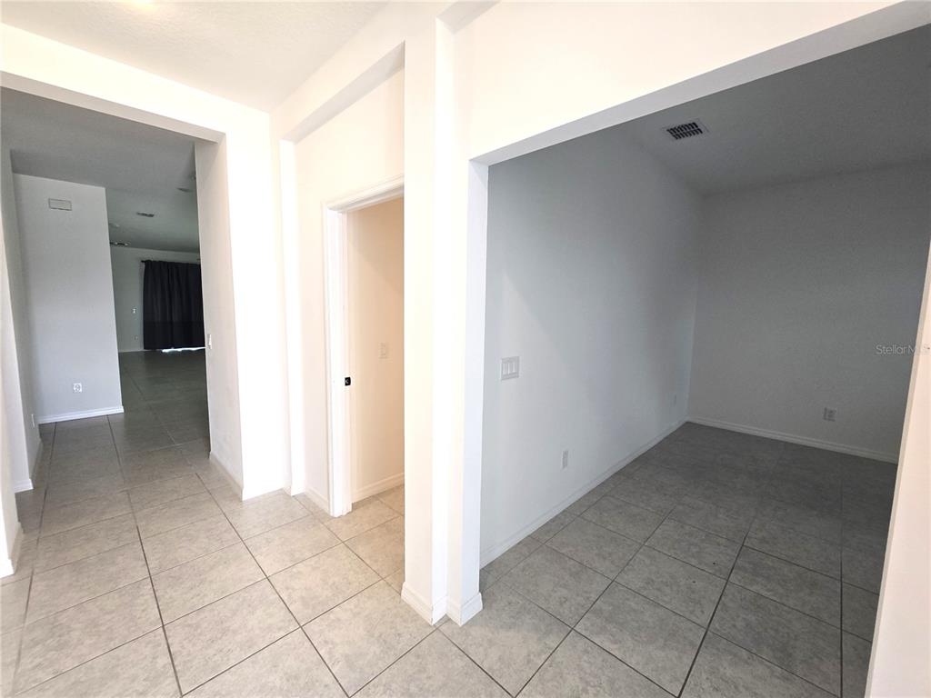 A tiled hallway leads to a doorway and an open room with white walls — 1225 TUPELO TRAIL, HAINES CITY, FL