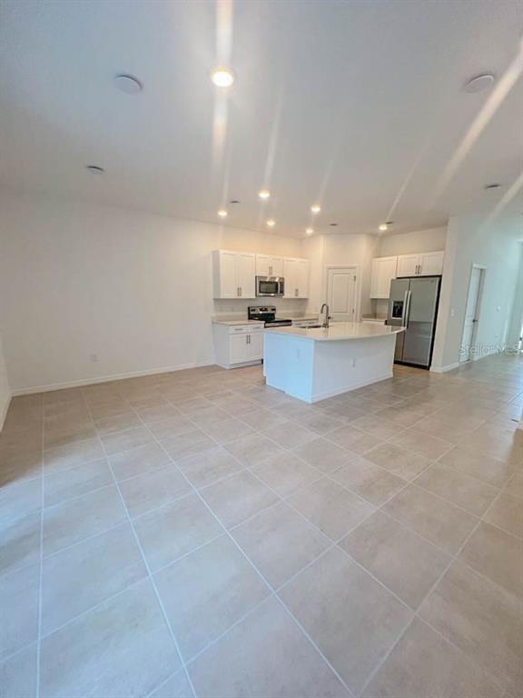 A kitchen with white cabinets, a central island, and light tile flooring — 3639 DAVENPORT CREEK COURT, KISSIMMEE, FL