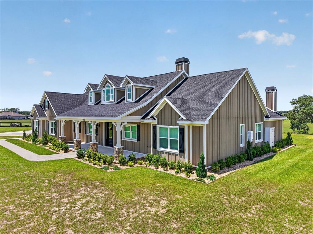 A single-story house with vertical siding, a covered porch, and a dark shingled roof — 5496 NANTAHALA LANE, LADY LAKE, FL