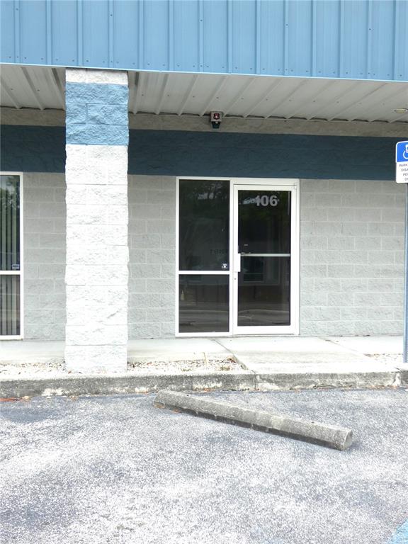 The exterior of a commercial building features a glass door labeled 106 and concrete blocks — 1882 PORTER LAKE DRIVE UNIT 106, SARASOTA, FL
