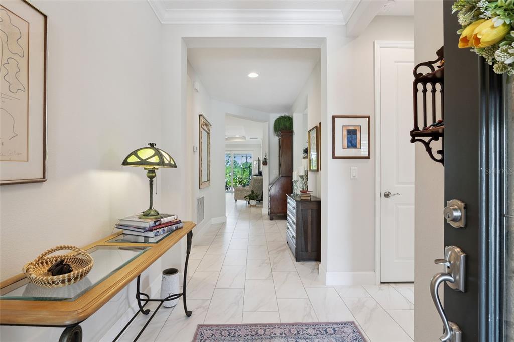 A bright entryway features white tile floors, a console table with a lamp, and hallway views — 965 AVERY MEADOWS WAY, DELAND, FL