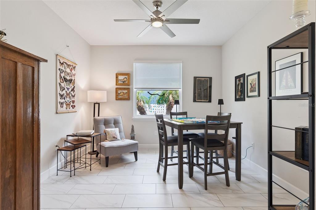 A dining room with a game table, a gray armchair, and tile flooring — 965 AVERY MEADOWS WAY, DELAND, FL