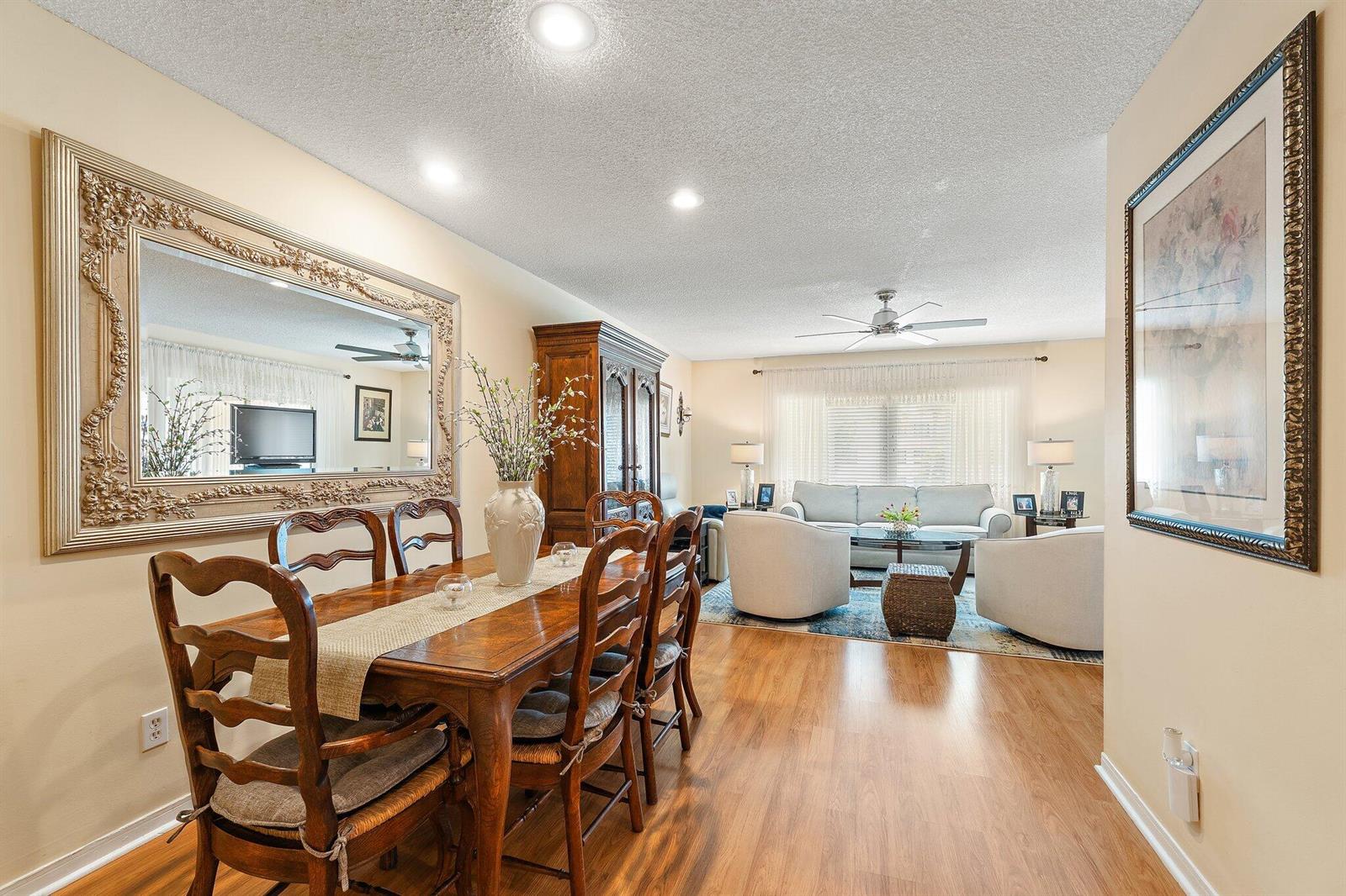A dining area with a wooden table and chairs opens into a living room — 1800 SE Saint Lucie Boulevard # 203, Stuart FL 34996, STUART, FL