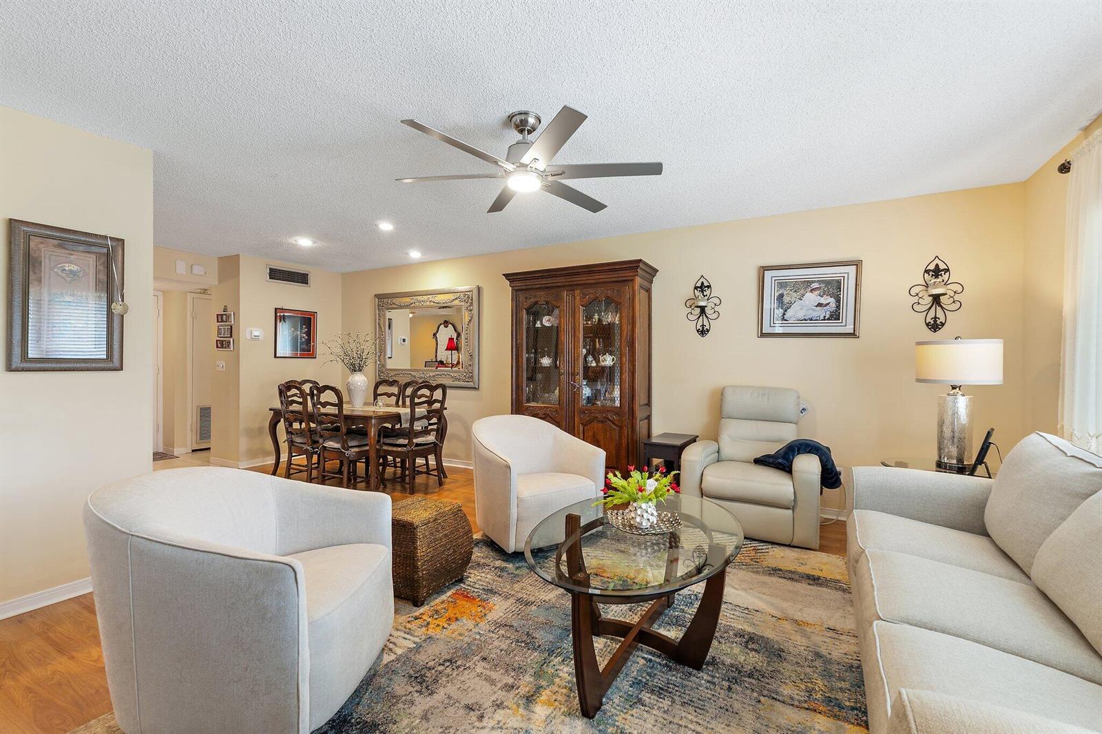 A living room with a dining area, beige walls, a ceiling fan, and neutral furniture — 1800 SE Saint Lucie Boulevard # 203, Stuart FL 34996, STUART, FL