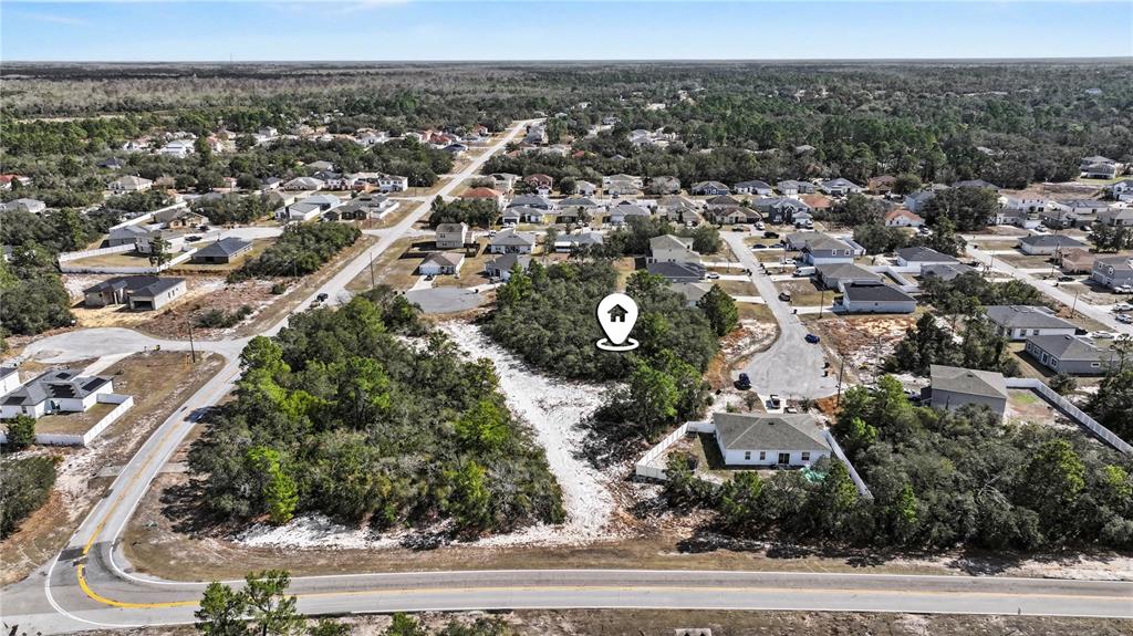An aerial view shows a vacant, wooded residential lot marked with a house icon — 611 AMAZON COURT, POINCIANA, FL