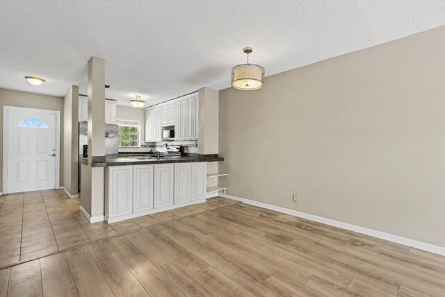 A kitchen with white cabinets and a breakfast bar opens into a dining area — 8327 Fairway Road # 8327, Sunrise FL 33351, SUNRISE, FL