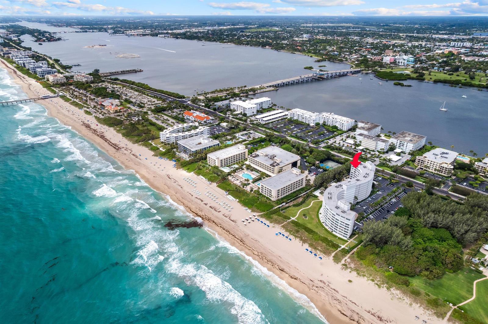 Aerial view of a curved beachfront condominium complex with a red arrow pointing to it — 2780 S Ocean Boulevard # 612, Palm Beach FL 33480, PALM BEACH, FL